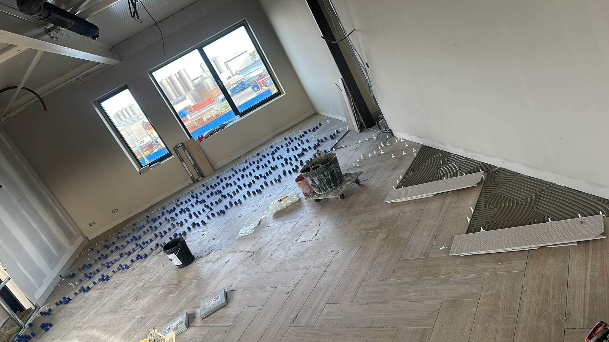 Grote houtlook visgraatvloer wordt gelegd met nivelleerclips