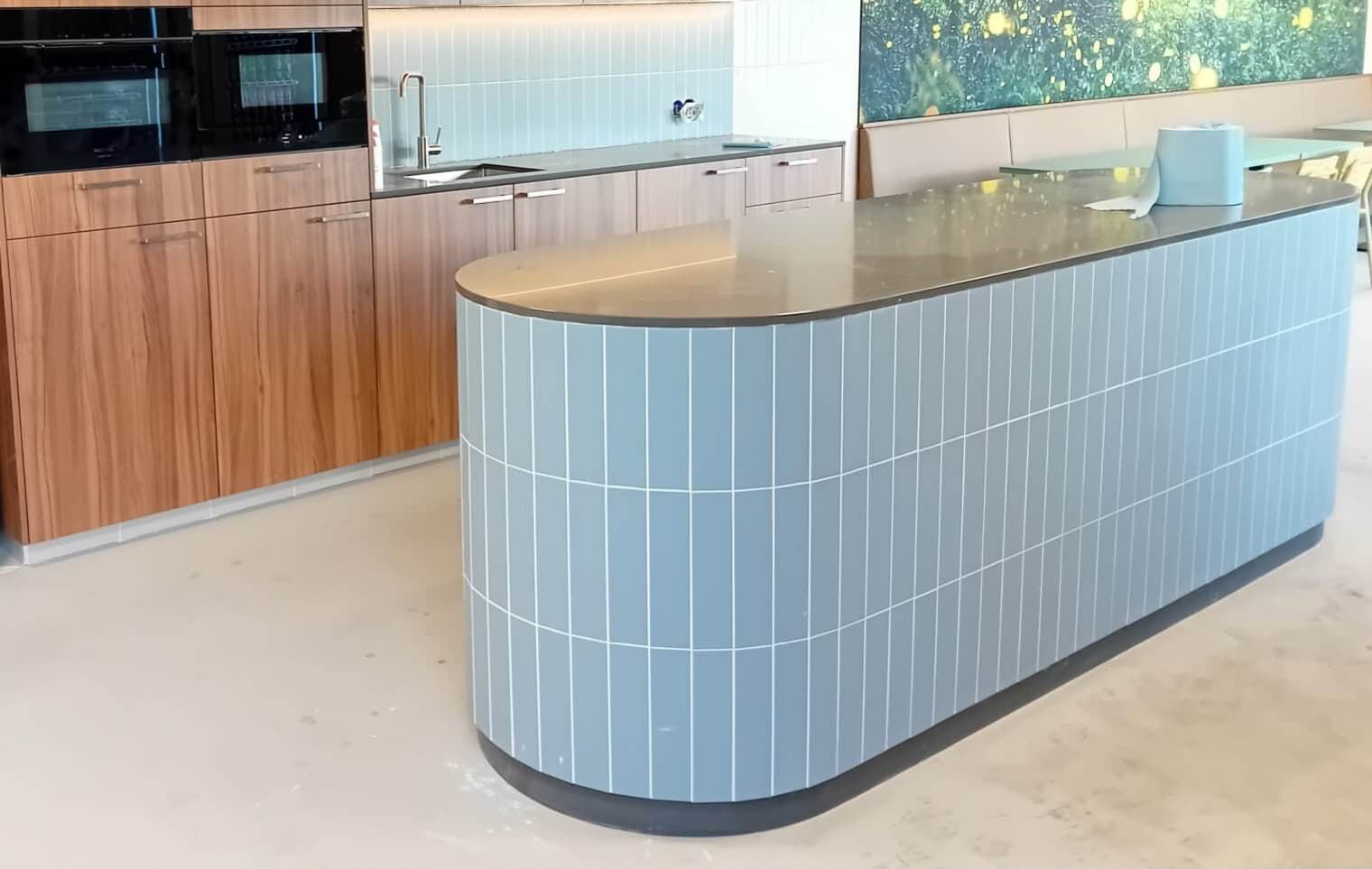 Gebogen kookeiland bekleed met lichtblauwe handvormtegels